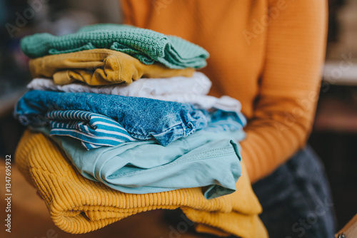 Close-up of female volunteer holding clothes collected for charity or converting discarded materials
