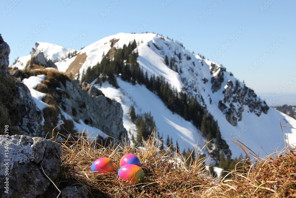 easter nest with colorful eggs, blurry alps background