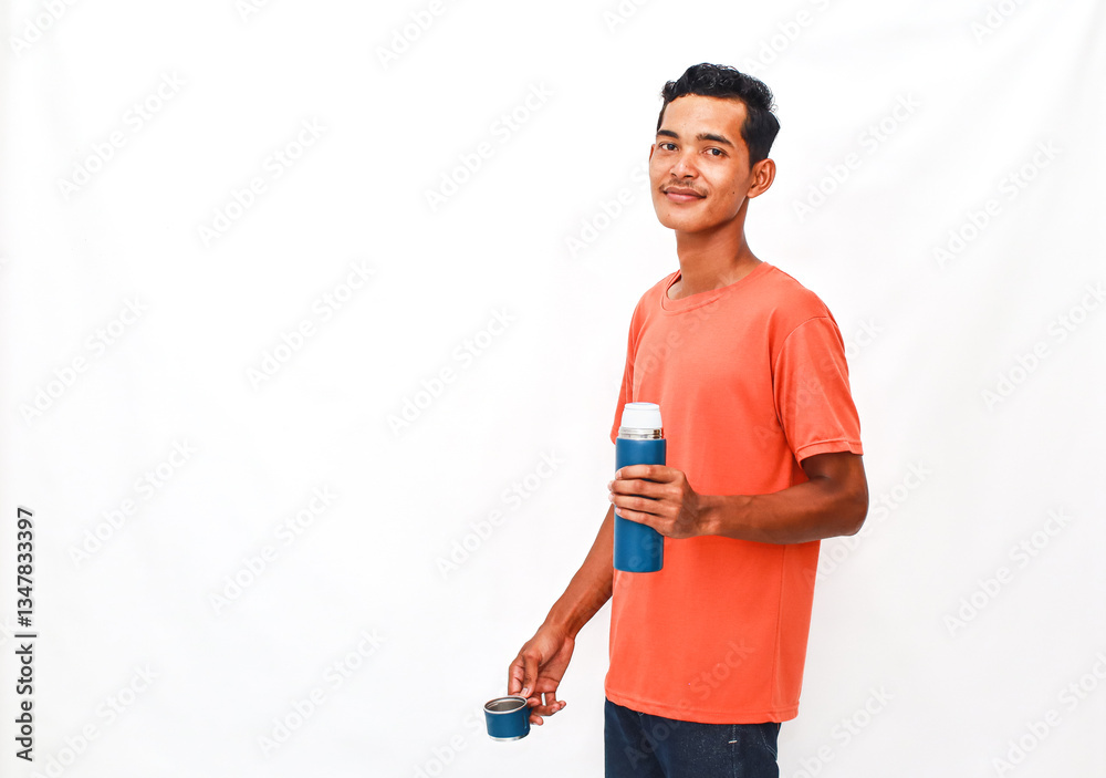 A Smiling Man Posing with a Thermos and a Cup Against a Plain Background