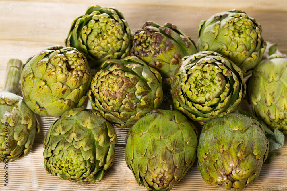 Obraz premium Fresh organic artichoke flowers on wooden table