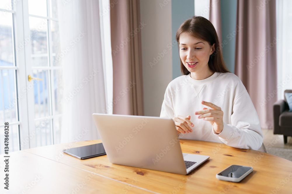 Young woman engaging in video conference from a cozy home setup during the daytime Young woman engaging in video conference from a cozy home setup during the daytime