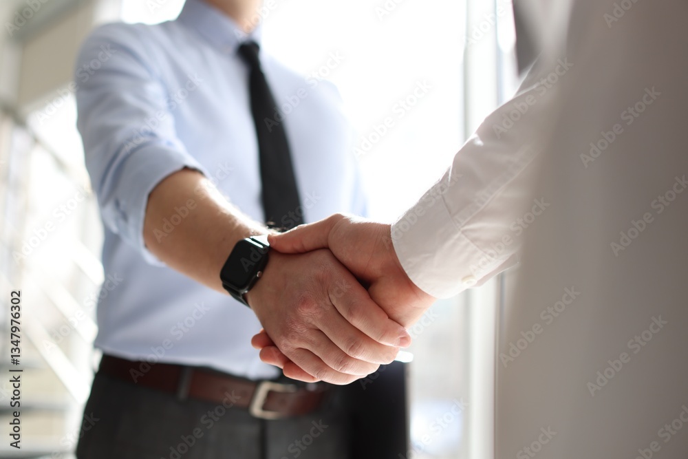Fototapeta premium Men shaking hands in agreement indoors, closeup