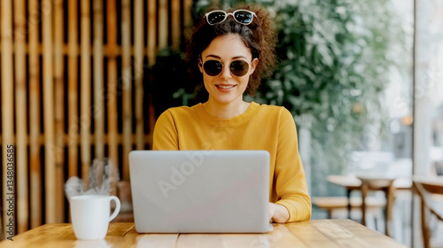 Female leader online working with laptop in modern minimalist Coworking​ Space cafe