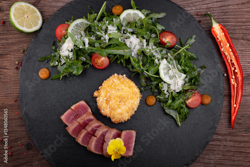 Tuna salad with fried poached egg on a slate plate