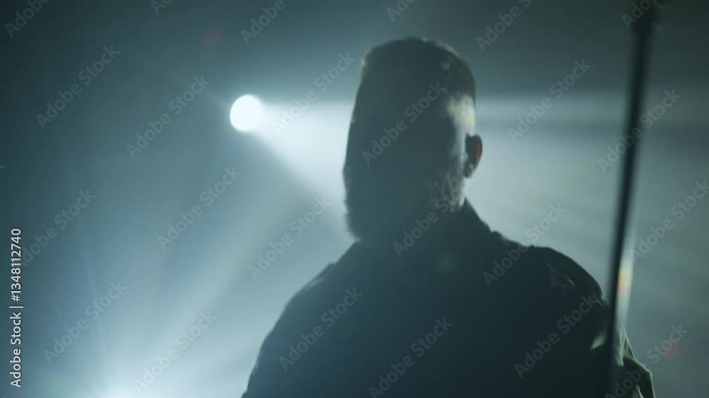 Musician singing and playing guitar on stage in slow motion