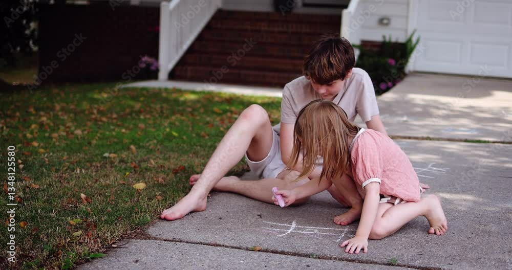 Brother and Sister Playing Tic Tac Toe with Chalk on Driveway – Fun Childhood Game on a Sunny Summer Day in Front Yard. Outdoor Summer Activity in Suburban Neighborhood