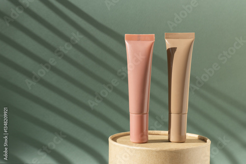 Mockup lip balm tube. Empty unmarked cosmetics containers on a round brown cardboard podium. Green background with Light on wall, sunlight, morning routine