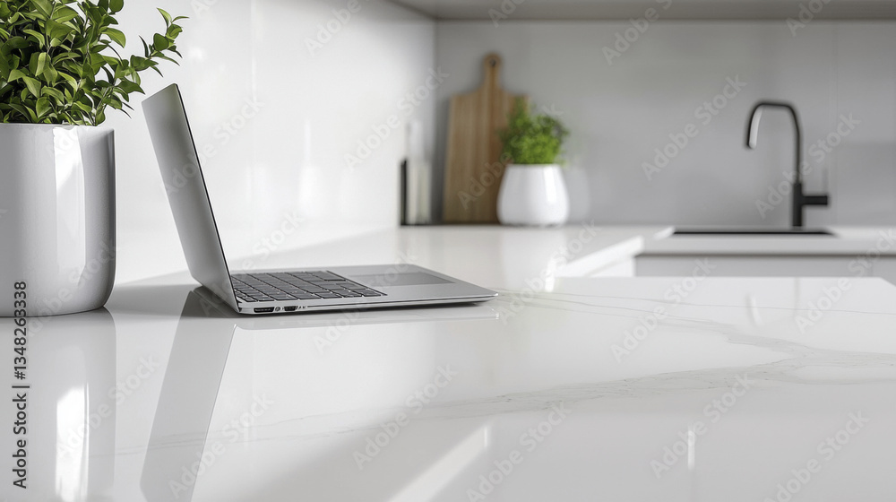 Obraz premium sleek white laptop rests on modern kitchen countertop, surrounded by greenery, creating fresh and inviting workspace