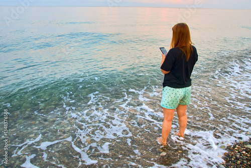 woman with phone at sea