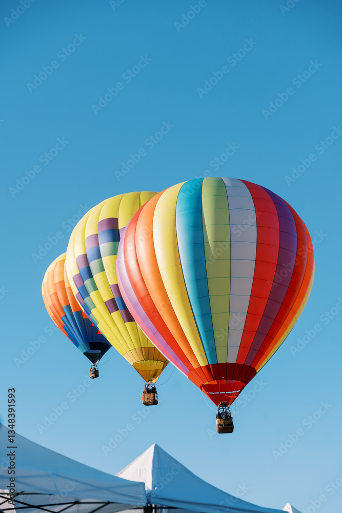 Fototapeta premium Colorful Hot Air Balloons Above Event Tents