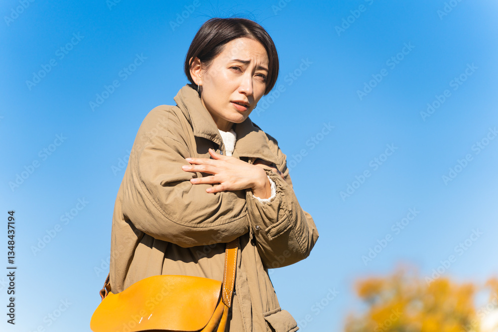 Fototapeta premium 冬空に凍える女性 ライフスタイルイメージ