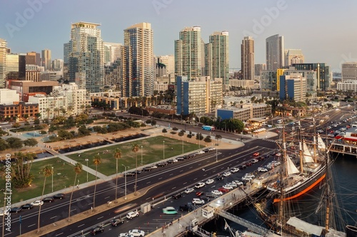 An aerial view of the Maritime Museum of San Diego, California, USA, featuring historic ships along the Embarcadero, with the city skyline in the background.