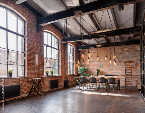 An industrial-style loft with exposed brick walls, metal beams, and Edison bulbs. photo