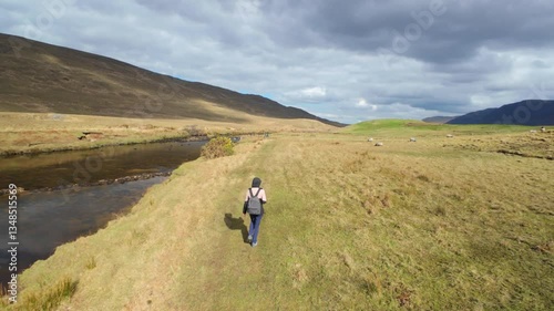 Woman backpacker hiking on trail by the Erriff river near Aesleagh falls, county Mayo, Ireland, aerial, Irish landscape, nature and mountains photo