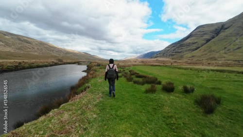 Woman backpacker hiking on trail by the Erriff river near Aesleagh falls, county Mayo, Ireland, aerial, Irish landscape, nature and mountains, hyper lapse photo