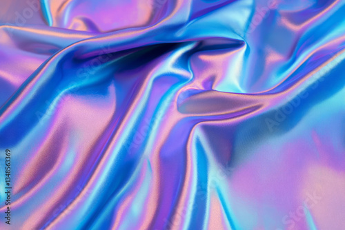 A futuristic holographic fabric texture background in iridescent blue, purple, and silver. The smooth, reflective surface changes colors with light angles, creating a mesmerizing, high-tech aesthetic,