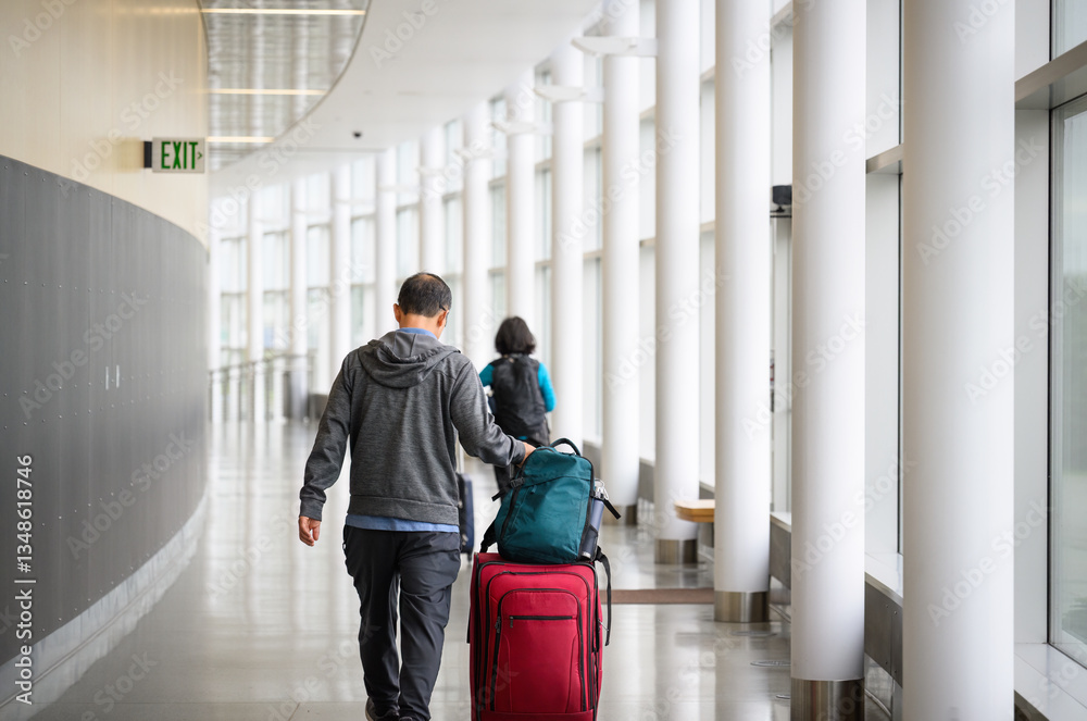 Couple pushing luggage suitcases and walking at the airport departure corridor.