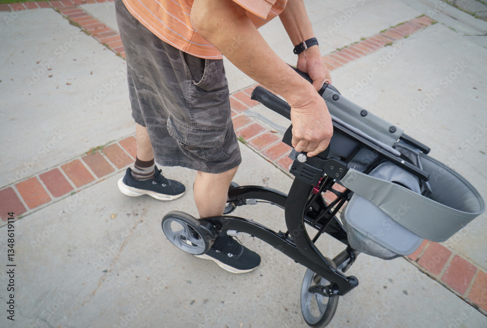 Man unfolding a mobility walker in the carpark, getting ready for elderly people. California.