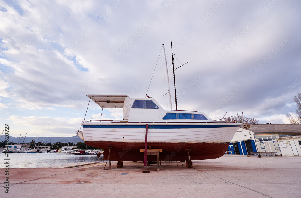 Fototapeta premium Sailboat in Dry Dock for Maintenance at Waterfront Harbor