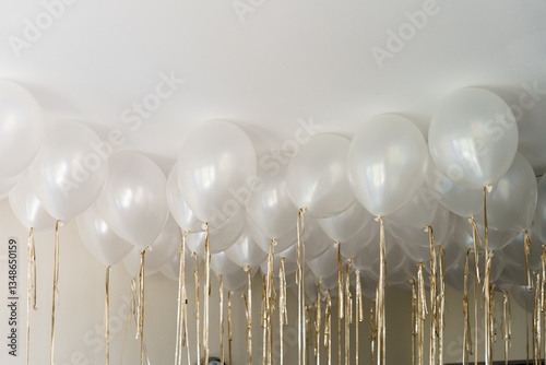 Many white balloons with gold ribbon ceiling