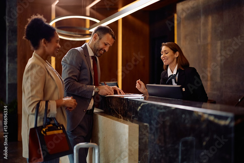 Happy business couple checking in at hotel.