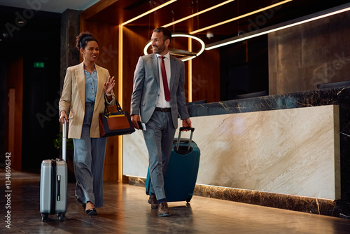 Happy coworkers arriving at hotel during their business travel.