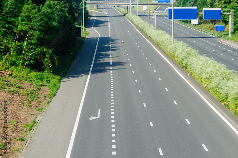 An empty, well-maintained highway surrounded by vibrant greenery, capturing the beauty of transportation infrastructure and the serenity of the environment it integrates with. An empty, well-maintained highway surrounded by vibrant greenery, capturing the beauty of transportation infrastructure and the serenity of the environment it integrates with.