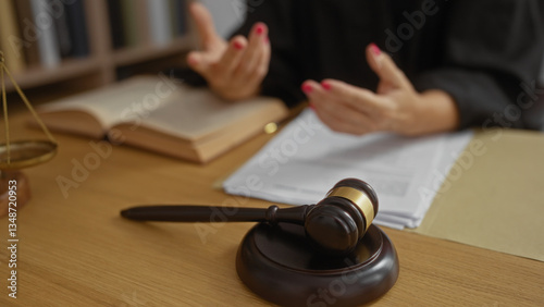 Bilde på lerret Woman talking in a courtroom with gavel on desk, hands gesturing near open book suggesting legal discussion