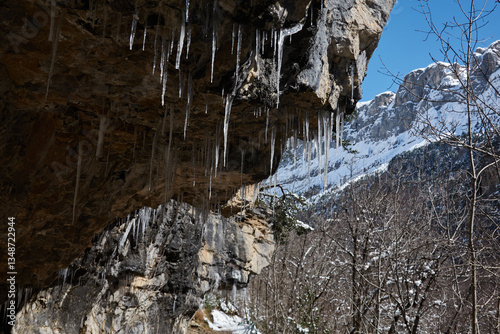 Icicles hang from the rocks along the path in the Ordesa Valley, within Ordesa and Monte Perdido National Park. A striking winter scene showcasing the frozen beauty of the Spanish Pyrenees