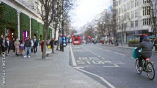 Wallpaper Mural Blurred pedestrians walking along a busy london street with iconic red buses on a cool winter afternoon in england, featuring defocused urban scenery and cycling activity. Torontodigital.ca