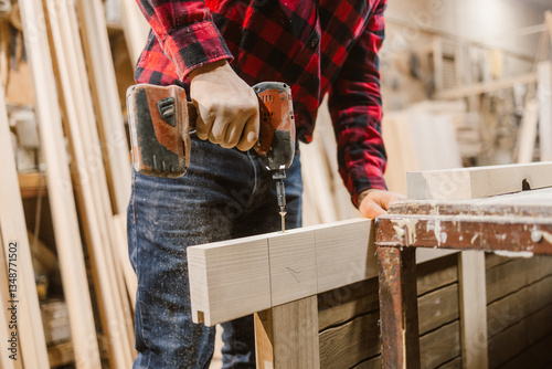 Carpenter Using Drill in Workshop