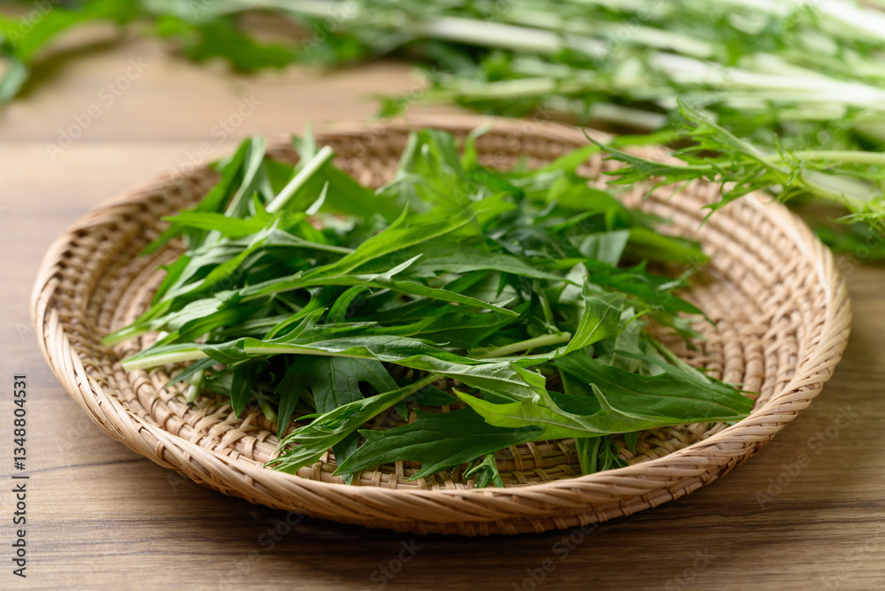 Mizuna, Water green, Japanese mustard green or spider mustard in basket on wooden background