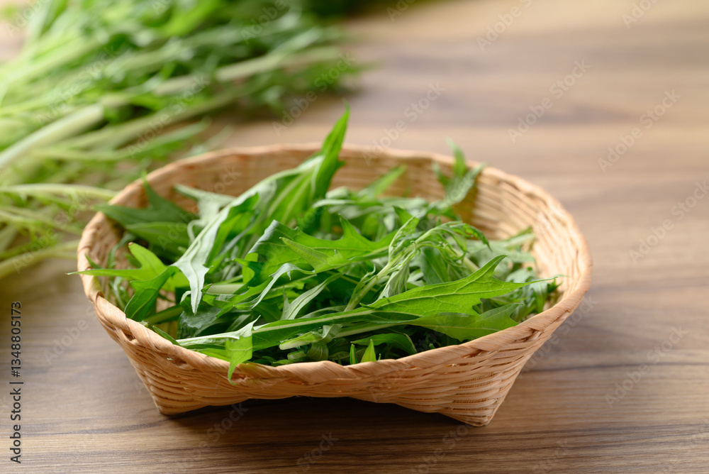 Mizuna, Water green, Japanese mustard green or spider mustard in basket on wooden background Mizuna, Water green, Japanese mustard green or spider mustard in basket on wooden background