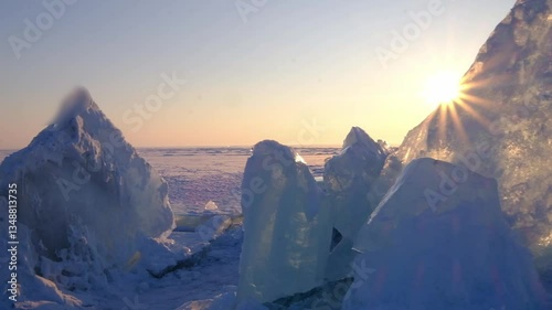 The sun rays illuminate a lake or northern sea covered with sparkling ice floes
