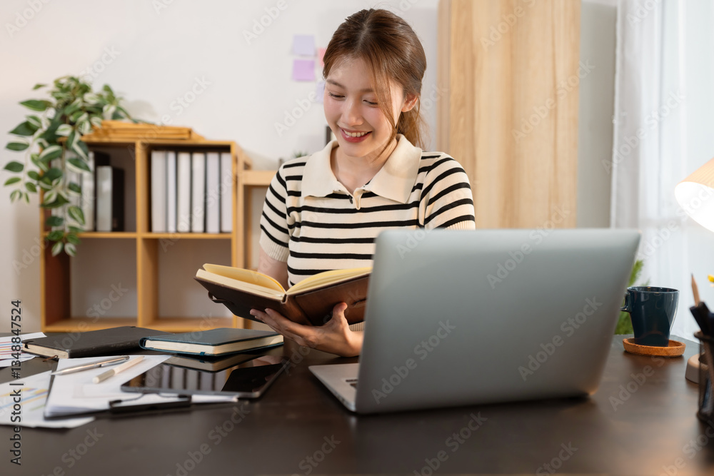 Lifestyle people. Woman reading a book and using laptop and enjoys a coffee. home office workplace. Lifestyle people. Woman reading a book and using laptop and enjoys a coffee. home office workplace.