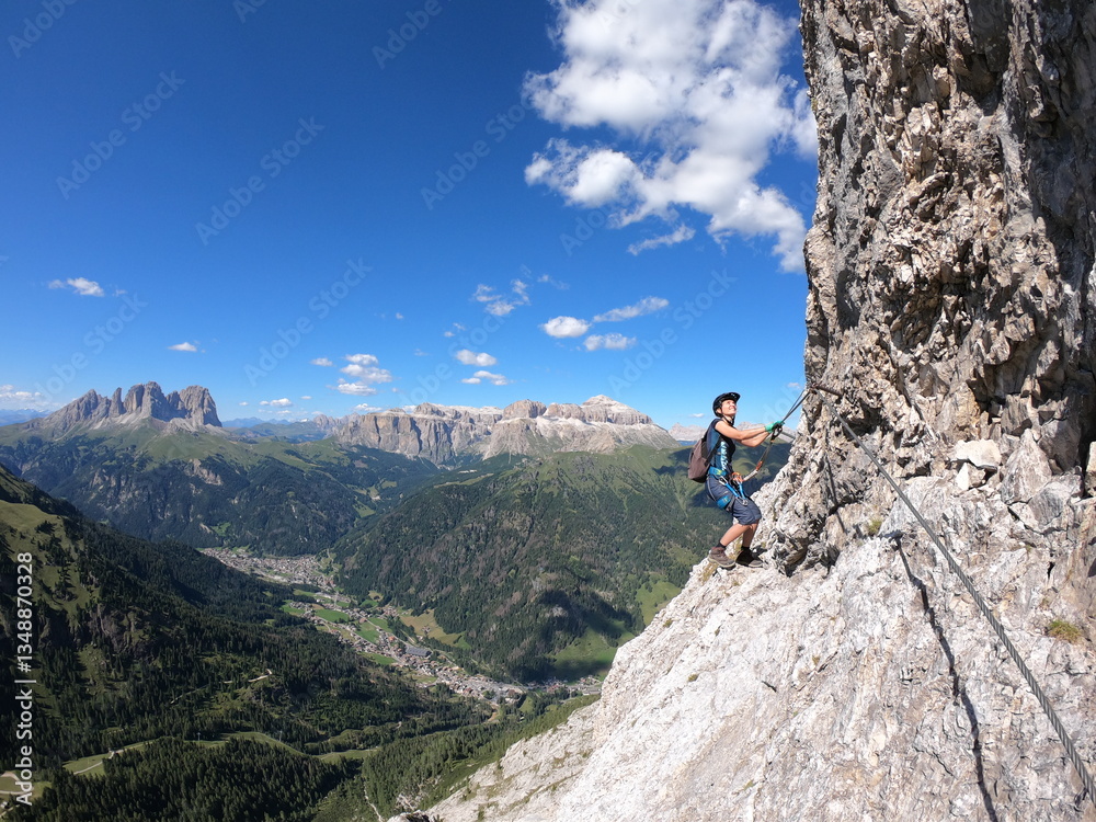 High on a rocky precipice, a figure gazes across a sprawling valley embraced by towering mountains, capturing the exhilarating freedom of exploration and the breathtaking natural panorama High on a rocky precipice, a figure gazes across a sprawling valley embraced by towering mountains, capturing the exhilarating freedom of exploration and the breathtaking natural panorama