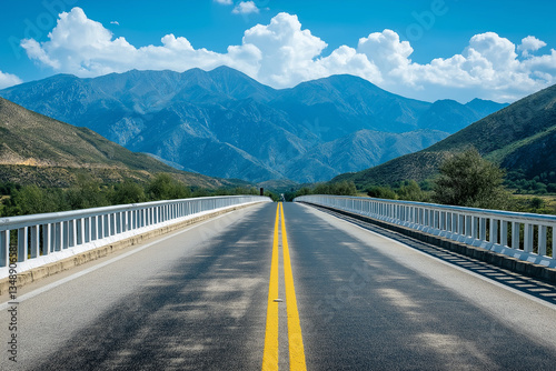 A wide road bridge with white guardrails and yellow traffic lines on the sides