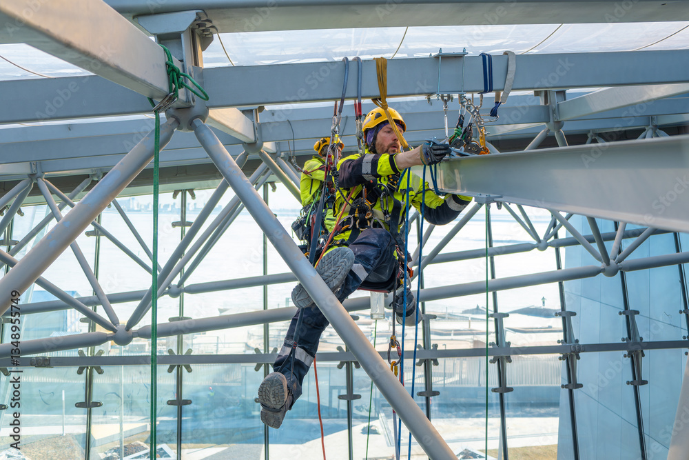 Fototapeta premium Rope access crew installs metal structure