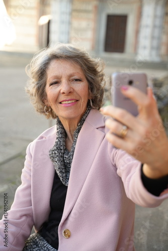 Elderly Woman Smiling and Taking a Selfie Outdoors