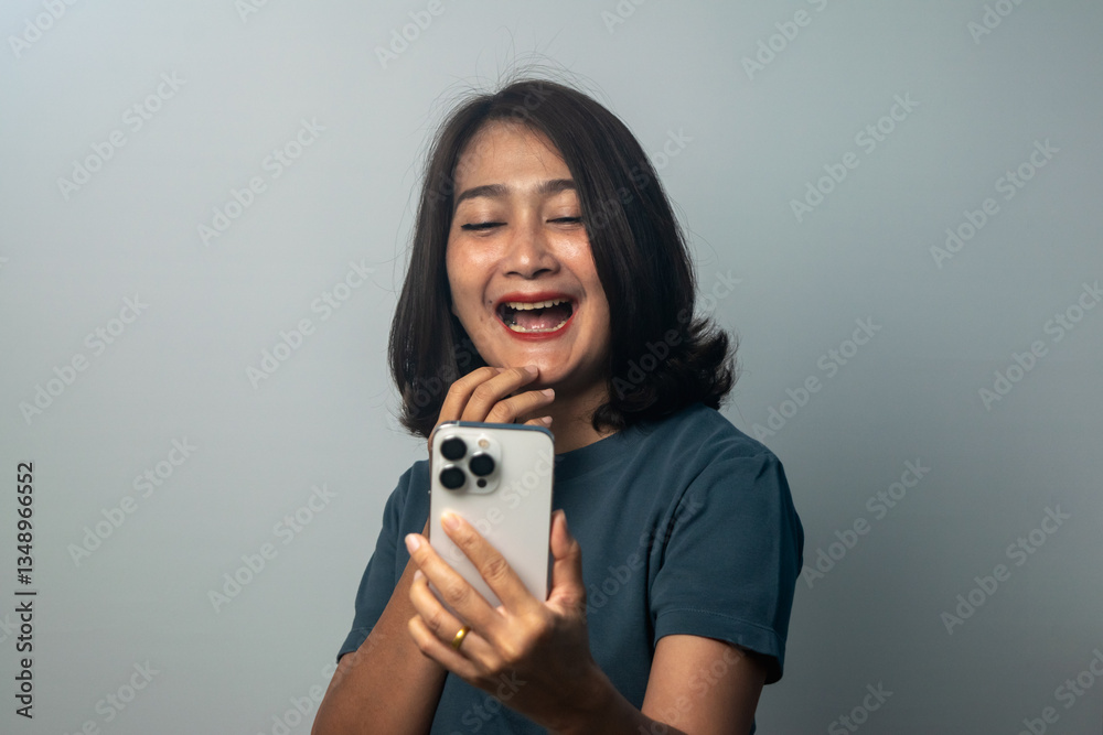 Women standing holding smartphone looking at phone wow surprise face expression feels shocked smile and happy laugh, enjoy fun relax lifestyles concepts Women standing holding smartphone looking at phone wow surprise face expression feels shocked smile and happy laugh, enjoy fun relax lifestyles concepts