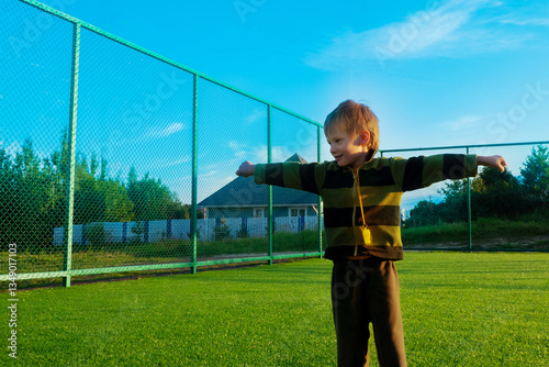 Obraz na płótnie The child goes in for sports at the stadium. The boy training before playing football. High quality photo w salonie