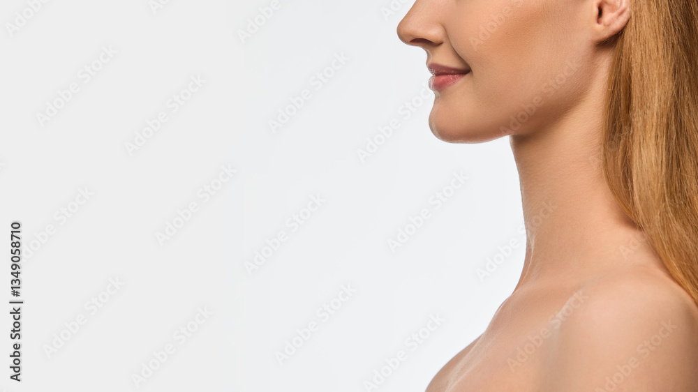 Side view close-up image focusing on female lower face, delicate smile, smooth lips, flawless skin texture. Perfect cheekbone, no double chin. Concept of wellness, skincare, cosmetics, cosmetology. Side view close-up image focusing on female lower face, delicate smile, smooth lips, flawless skin texture. Perfect cheekbone, no double chin. Concept of wellness, skincare, cosmetics, cosmetology.
