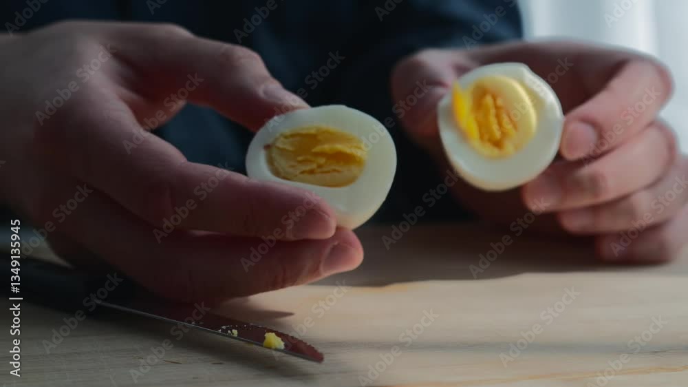 A man cuts a chicken egg in half.
Two halves of a chicken egg.
Chicken yolk.
Peeled boiled egg.
Boiled chicken egg close-up on a kitchen board