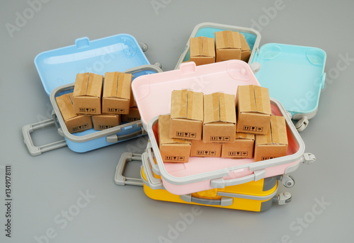 Carton boxes inside travel suitcases on gray background. Shopping and travel concept.