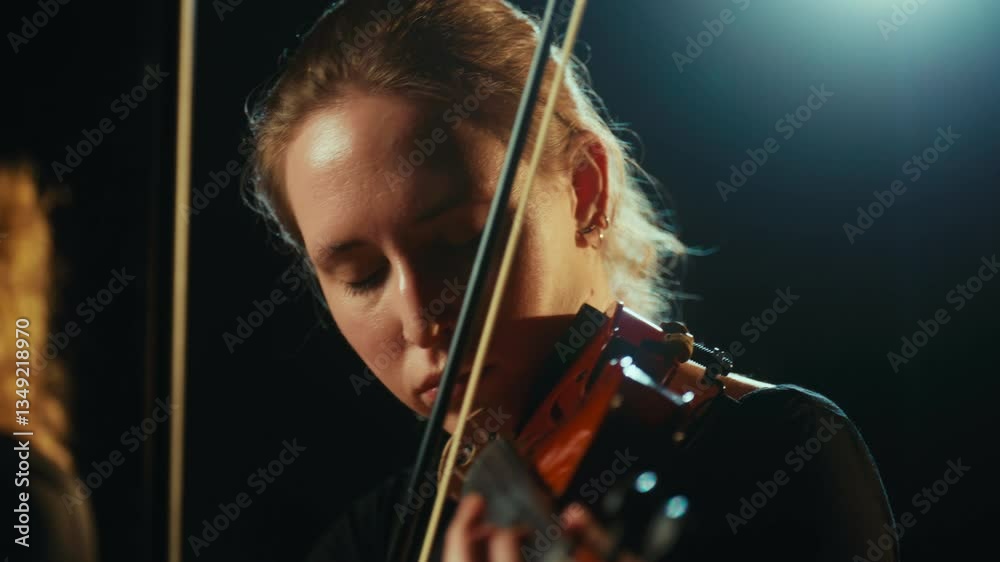 Play violin and enjoy music, young woman expressing emotions by art, portrait. Beautiful female musician performing contemporary classical music on stage, reflection in mirror and rain in background