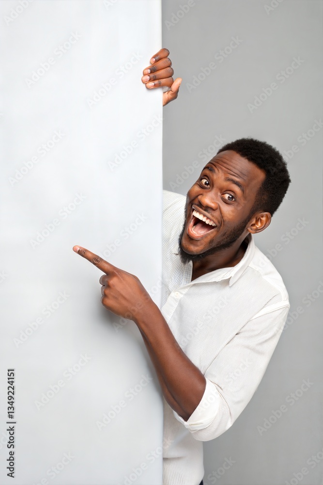 Cheerful, overjoyed African-American man pointing fingers at empty copy space against a grey background, recommending a deal, advertising a product. (Prize)