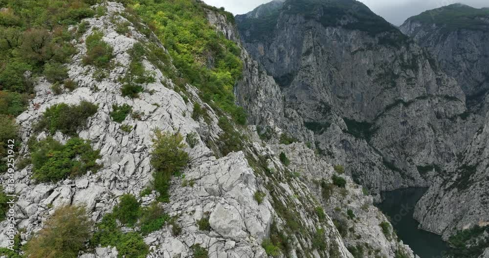 Vertical Canyons Surrounding Lake Koman On Drin River In Kukes, Shkoder, Albania. panning drone, tilt-down reveal Vertical Canyons Surrounding Lake Koman On Drin River In Kukes, Shkoder, Albania. panning drone, tilt-down reveal