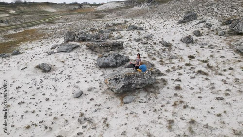 Wallpaper Mural A mother and child practice meditation while sitting on a rock in a dry, rugged landscape. They focus on relaxation and mindfulness, enjoying a peaceful moment surrounded by nature Torontodigital.ca