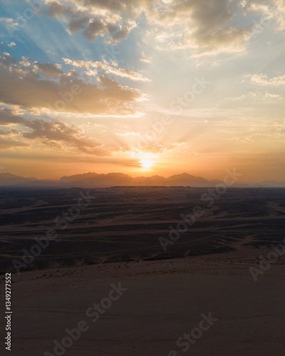 Dramatic sunset over Red Sea mountains with golden clouds, Egypt