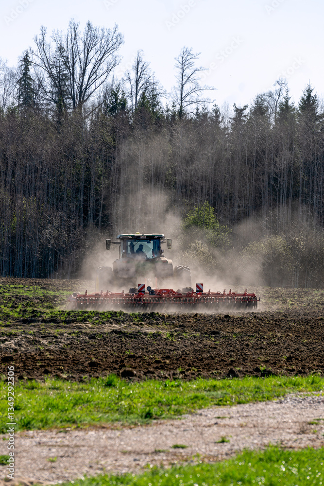 Fototapeta premium A tractor plows a field in early spring.